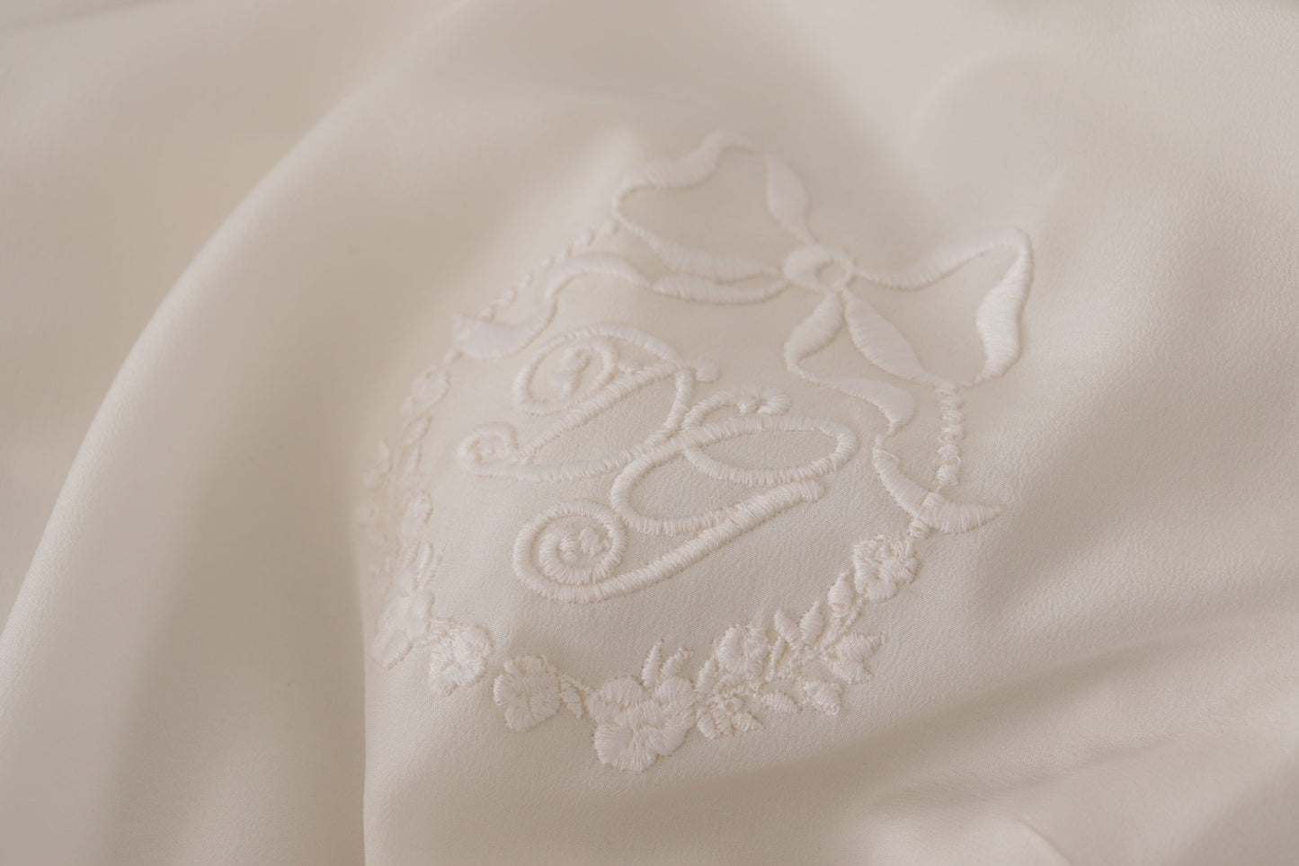 بلوزة دولتشي آند غابانا الحريرية البيضاء المطرزة بشعار DG بأكمام طويلة