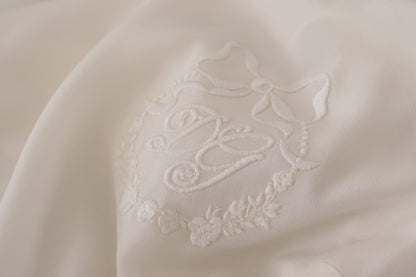 بلوزة دولتشي آند غابانا الحريرية البيضاء المطرزة بشعار DG بأكمام طويلة